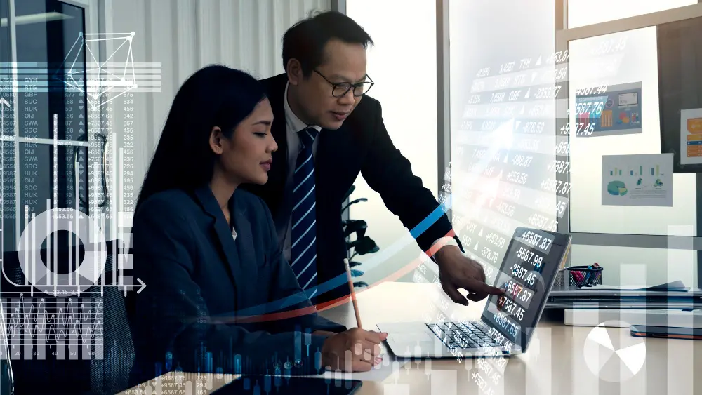 Mulher e homem apontando para notebook com gráficos ilustrados  de empresas de integração Shopify